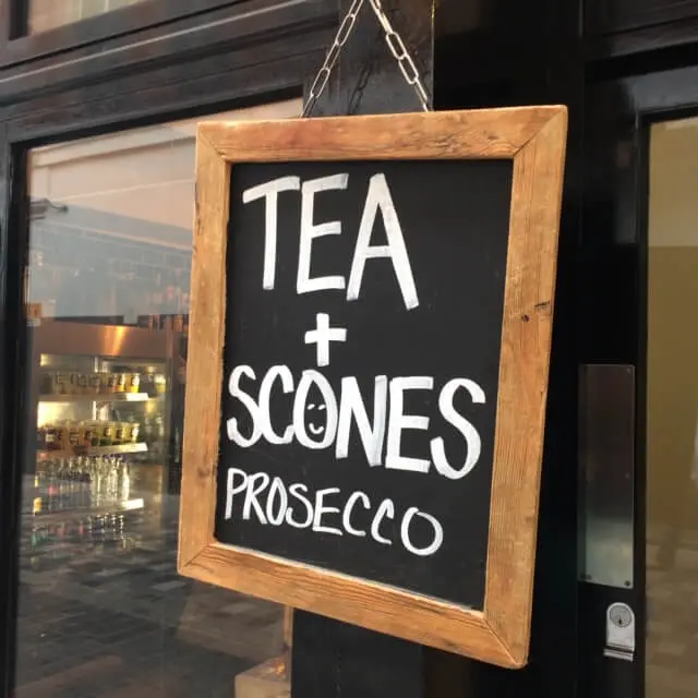 Tea Scones and Prosecco Sign Hanging on a London Cafe